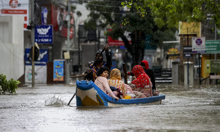 Residents are being ferried to safety through a flooded-Chennai street.