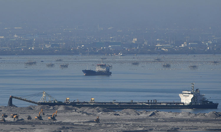 A barge unloads sand at a reclamation site in Manila Bay on March 14, 2023. AFP