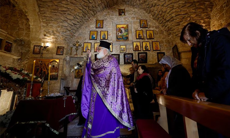 Christian worshipers pray during Mass inside St. George Church, also known as the Church of the Ten Lepers, in Burqin, near Jenin, in the Israeli-occupied West Bank. Reuters