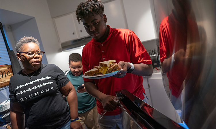 Melanese Marr-Thomas and her sons, Savion Thomas (centre), and Zachary Marr, prepare dinner at home in District Heights, Maryland. Associated Press