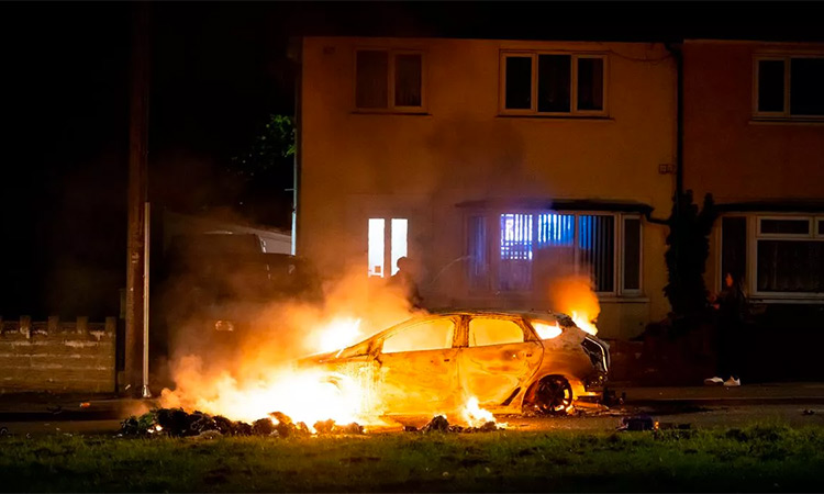 A car goes up in flames during riots in Ely, Cardiff. (Image via Twitter)