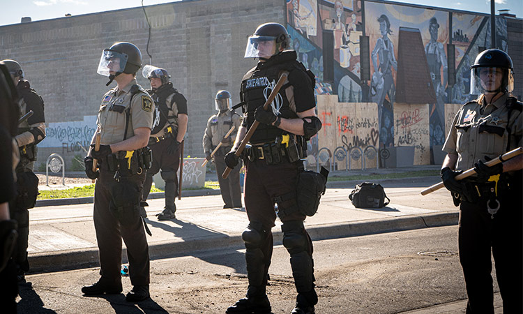 Police officers stand guard towards George Floyd protestors in Minneapolis, Minnesota. (UnSplash)