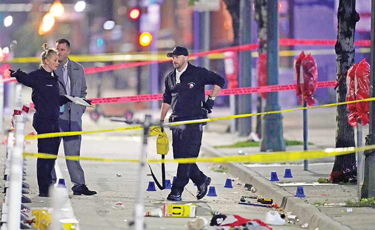 Denver Police Department investigators work on the scene of a mass shooting along Market Street between 20th and 21st avenues in Denver. 