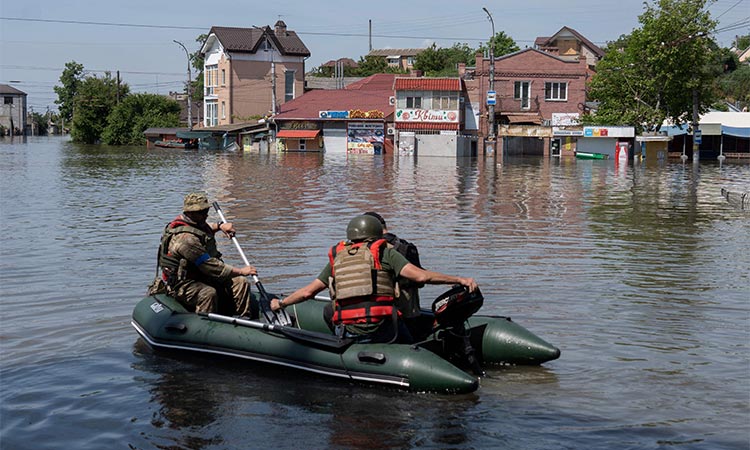 Ukrainian security forces transport local residents in a boat during an evacuation from a flooded area in Kherson on Wednesday, following the destruction of Kakhovka hydroelectric power plant dam.  Agence France-Presse
