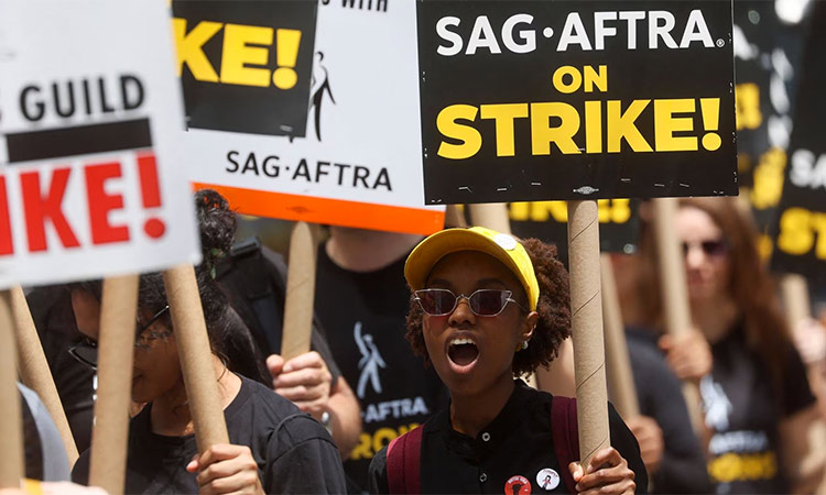 Striking Writers Guild of America (WGA) and Screen Actors Guild (SAG) members walk the picket line during their strike in New York City. Reuters