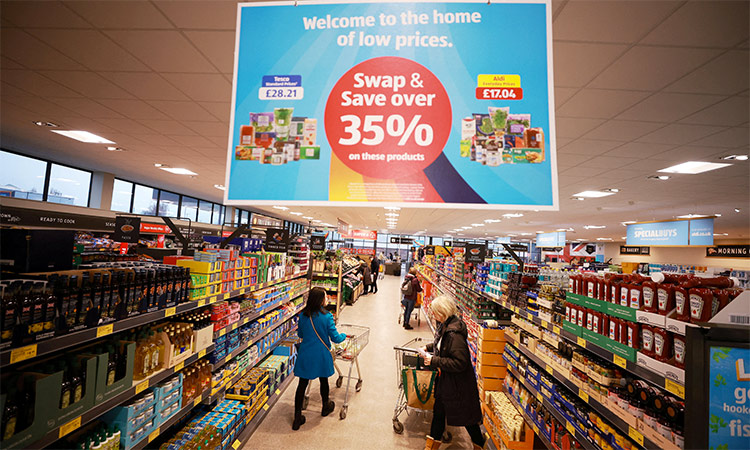 Shoppers push trolleys along an aisle inside an ALDI supermarket near Altrincham, Britain. Reuters