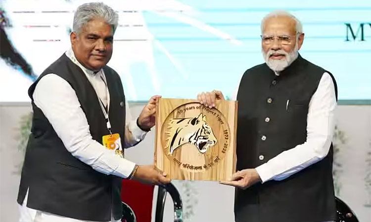 Prime Minister Narendra Modi is presented with a 'Tiger Memento' by Bhupender Yadav at the Mysuru University, Mysuru. (Image via Twitter)
