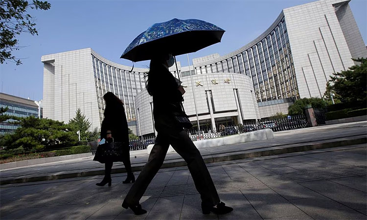 People walk past the headquarters of the People's Bank of China, the central bank, in Beijing, China. File/Reuters