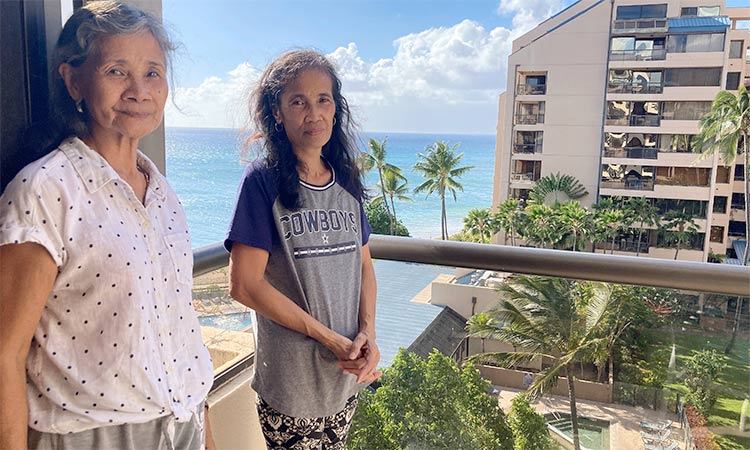 Evangeline Balintona (left) and Elsie Rosales pose on the balcony of a hotel room in Lahaina, Hawaii.