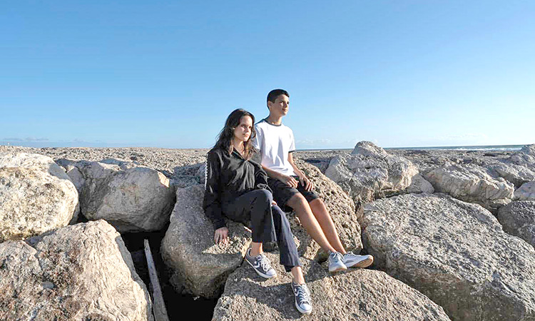 Siblings Sofia Oliveira, 18, and Andre Oliveira, 15, pose for a picture at the beach in Costa da Caparica, south of Lisbon. AP