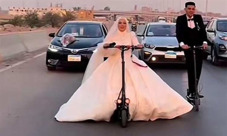 A videograb shows Egyptian couple riding e-scooter in their wedding attire.