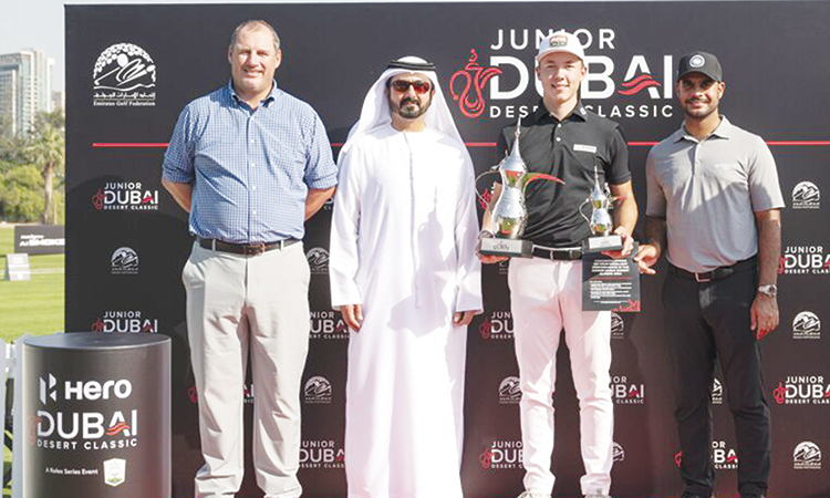 Viktor Kofod Olsen poses with the trophies along with officials during the prize distribution ceremony of the Junior Dubai Desert Classic at the Emirates Golf Club.