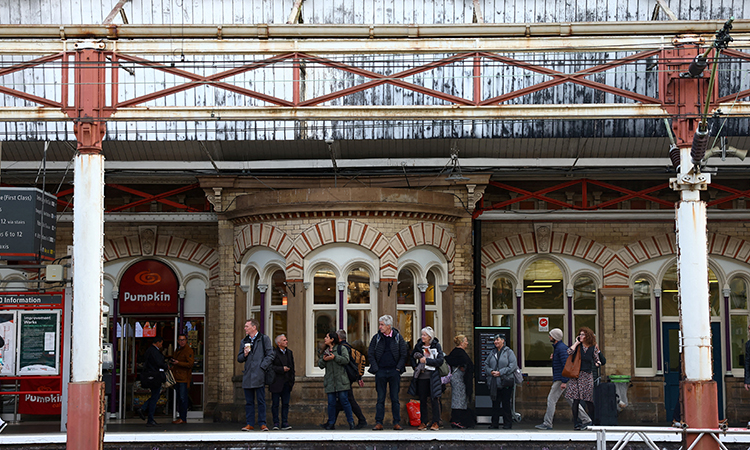 People wait for a train on a platform at Crewe Station in Crewe, Britain. Reuters