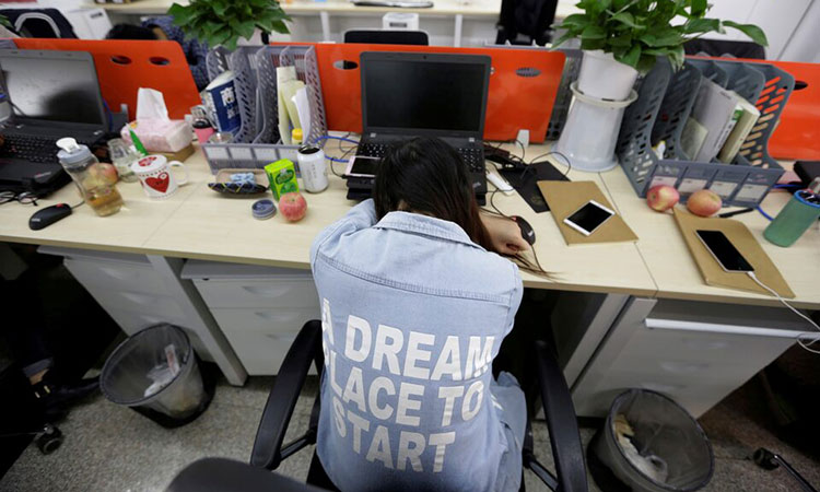 Yang Juan, an employee at Goopal Group, takes a nap in her seat after lunch, in Beijing, China.   Reuters