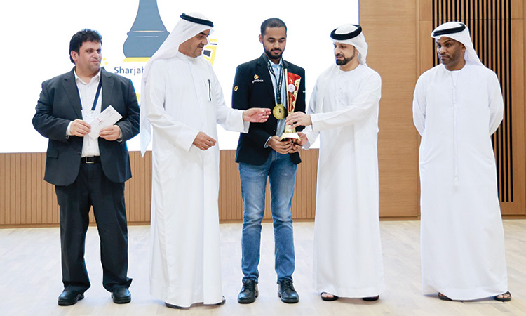 Sheikh Saud Bin Abdul Aziz Almualla and Dr Sheikh Khalid Bin Humaid Al Qasimi give the trophy to Arjun Erigaisi as other dignitaries look on.