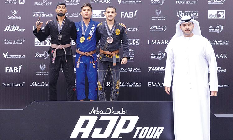 Winners pose with a UAE Jiu-Jitsu Federation official during the presentation ceremony.