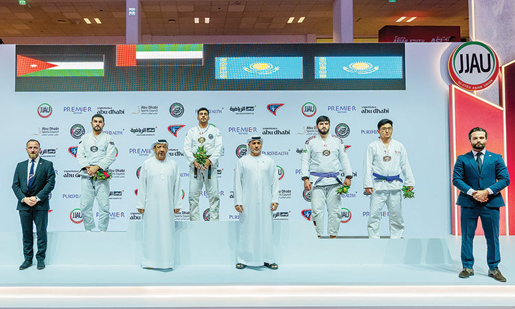 Winners pose on the podium with officials during the presentation ceremony.