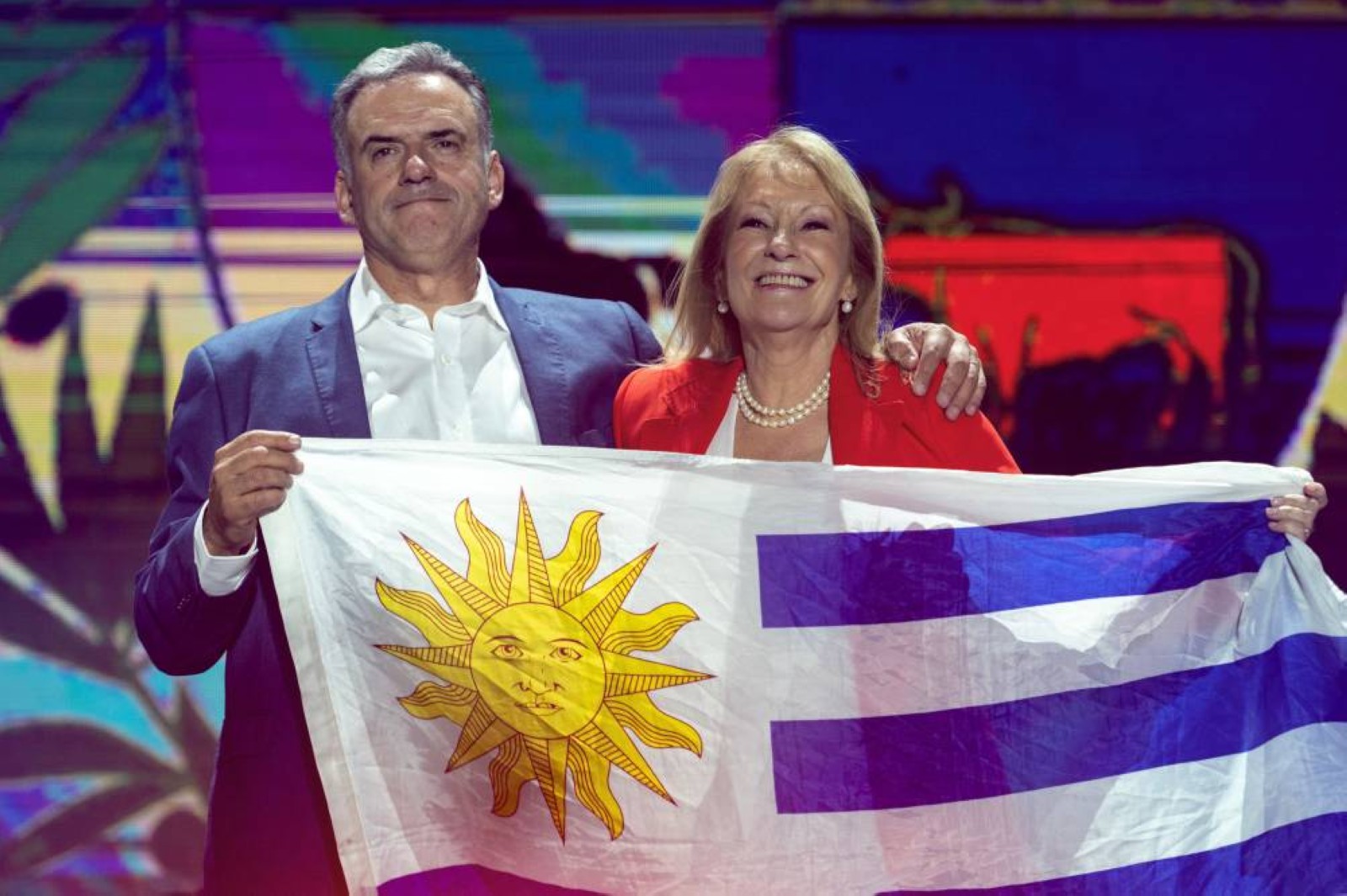 Uruguay's President-elect, Yamandu Orsi (left), and Vice-President-elect Carolina Cosse hold a Uruguayan flag during their victory speech after the presidential runoff election in Montevideo on Sunday. Associated Press