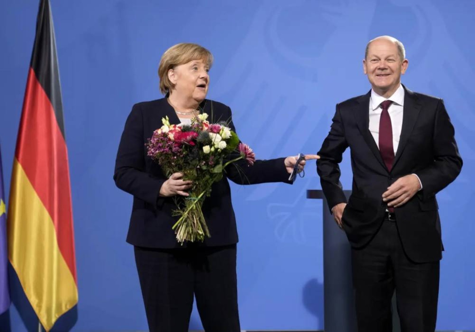 German Chancellor Olaf Scholz (right), has given flowers to former German Chancellor Angela Merkel during a handover ceremony in the chancellery in Berlin. File/Associated Press