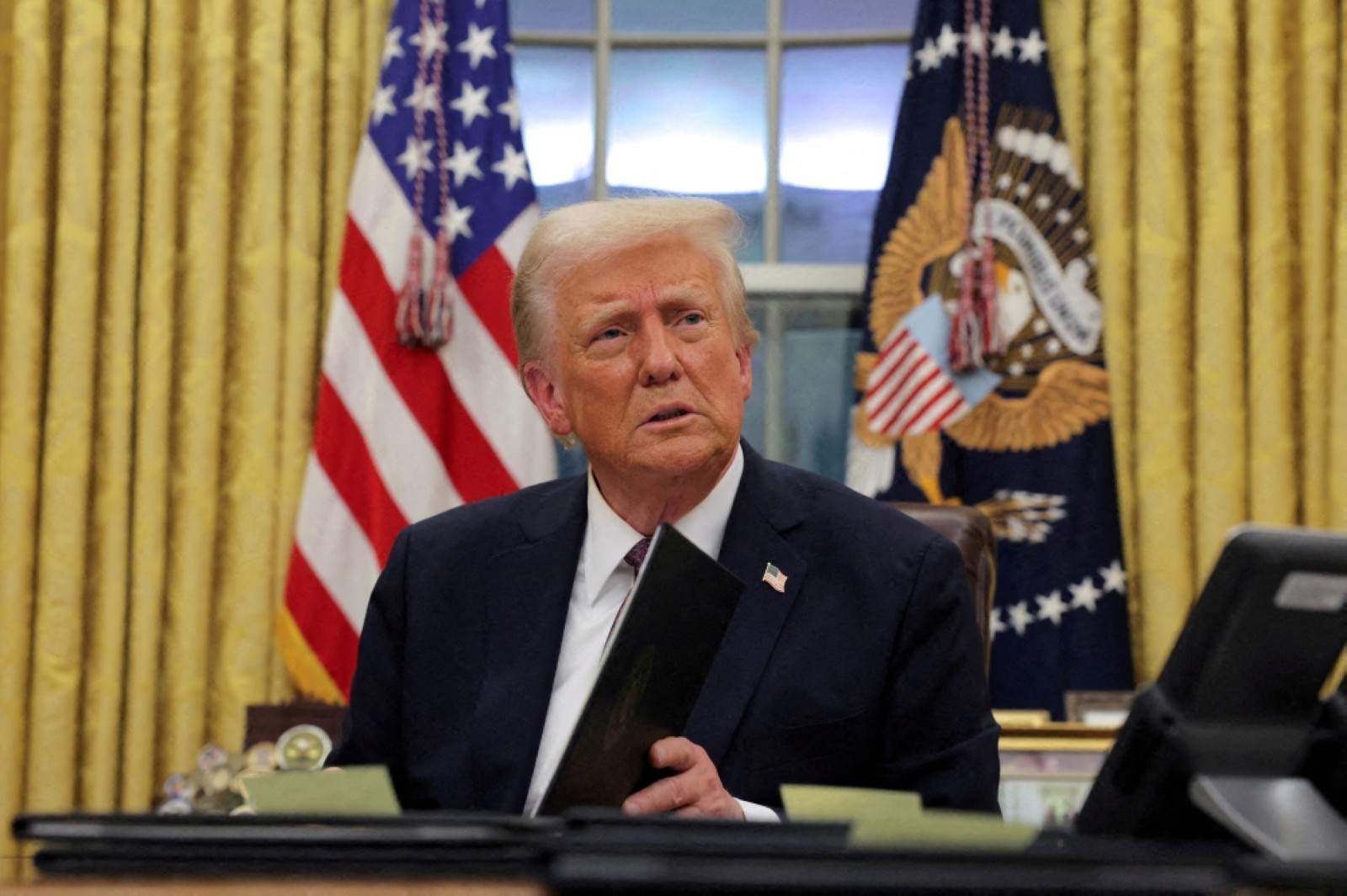 President Donald Trump signs documents as he issues executive orders in the Oval Office at the White House on Inauguration Day in Washington. Reuters