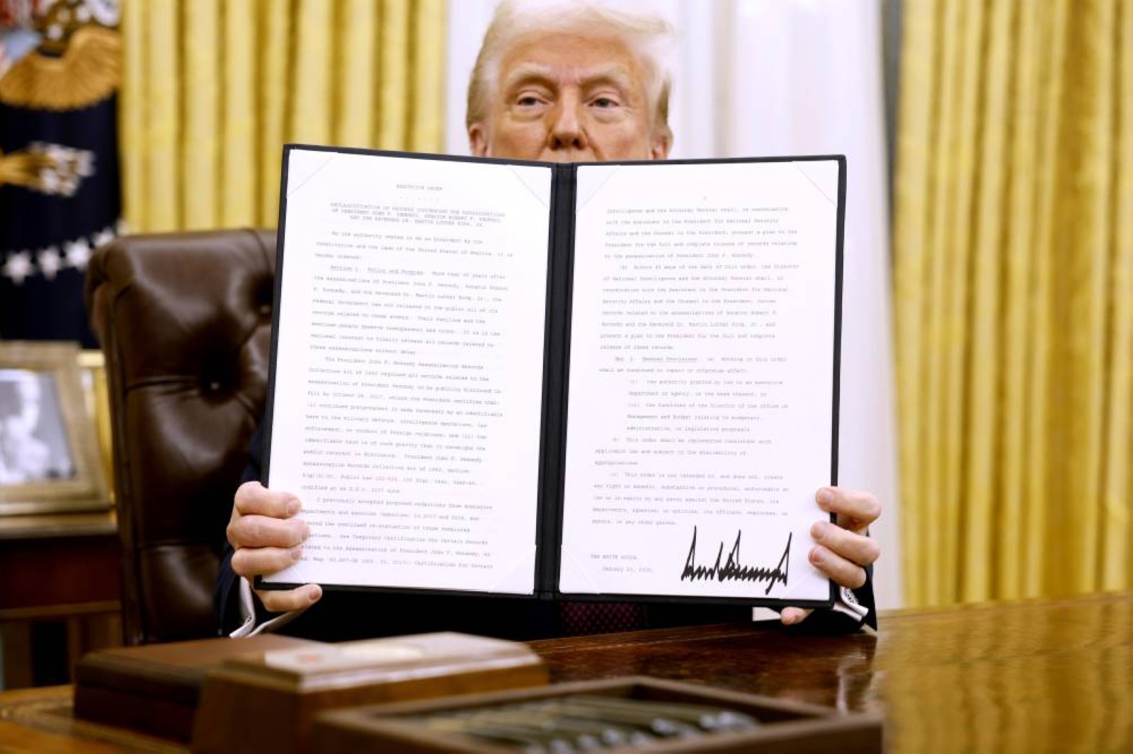 Donald Trump holds up a signed executive order in the Oval Office of the White House on Jan.23, 2025, in Washington, D.C. File/Tribune News Service