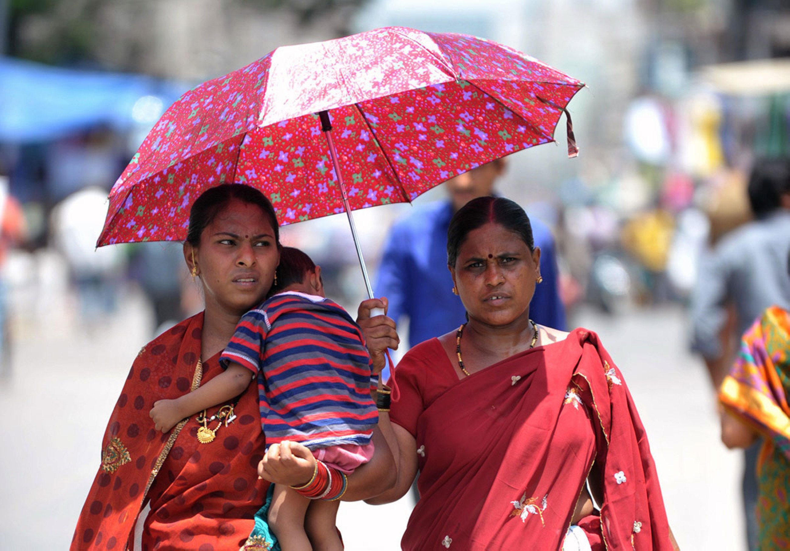Indian women walk under an umbrella on a hot summer day in Hyderabad, India. File/AFP