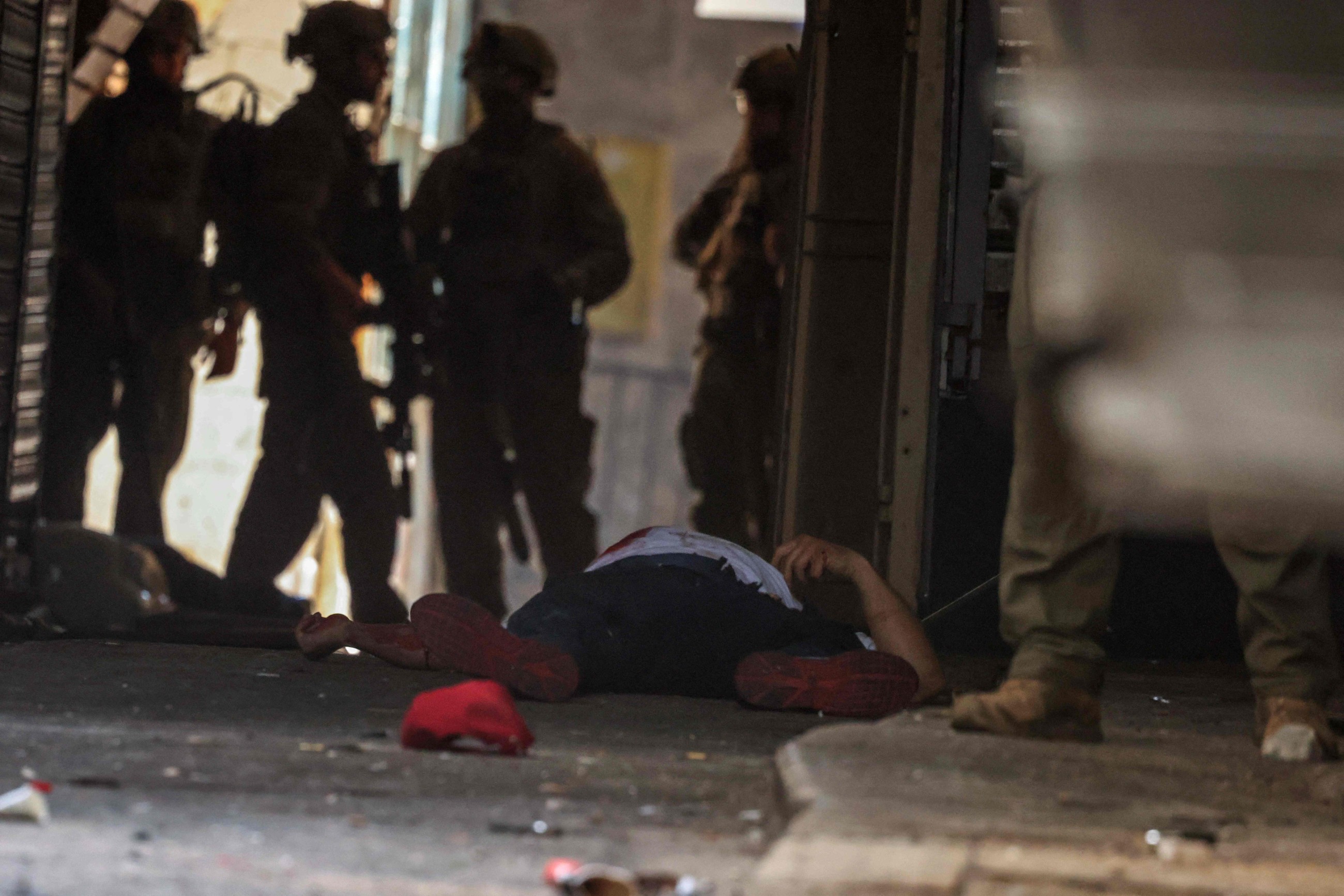 Israeli soldiers stand around two bodies on the ground during a raid in the old town of Nablus city, West Bank. AFP