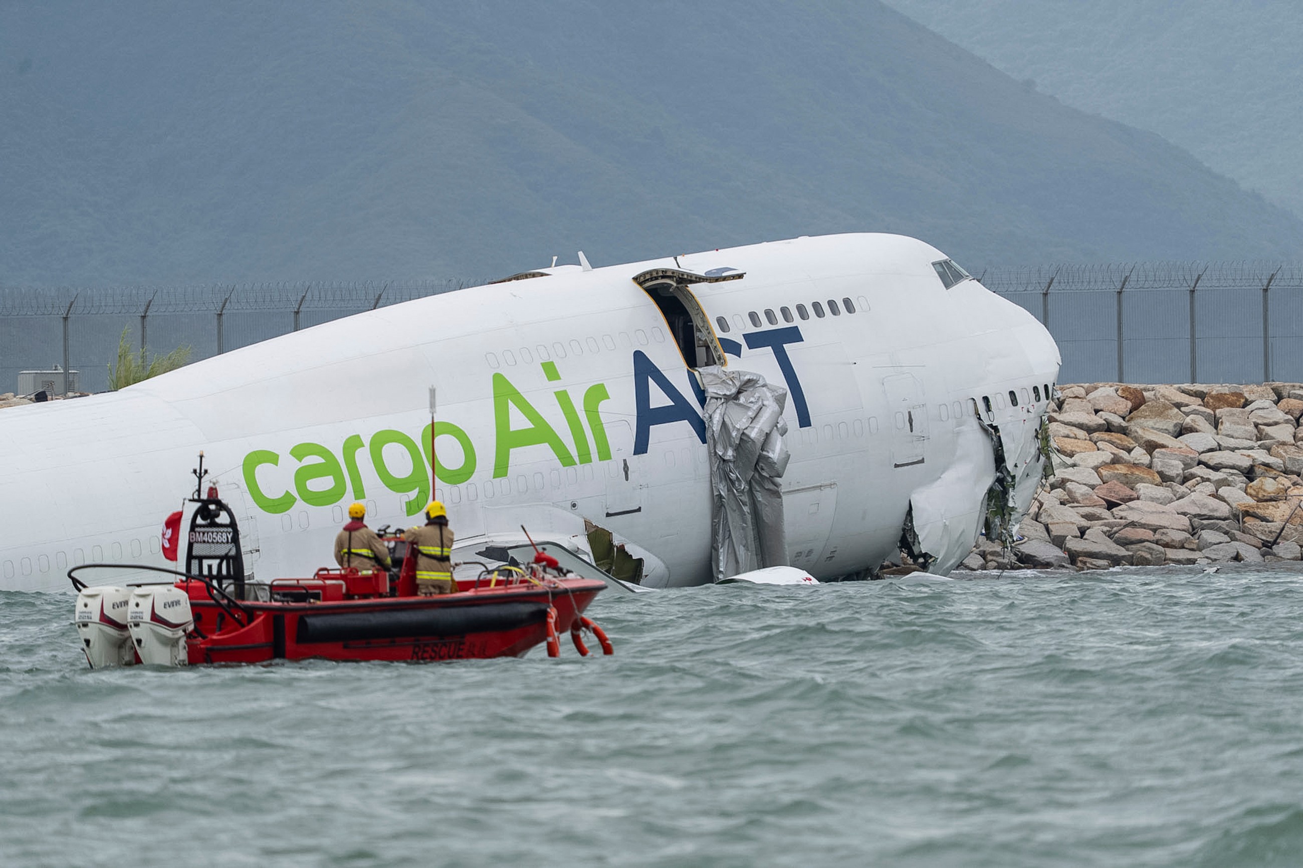 Two airport staff killed after cargo plane slides off runway in Hong Kong