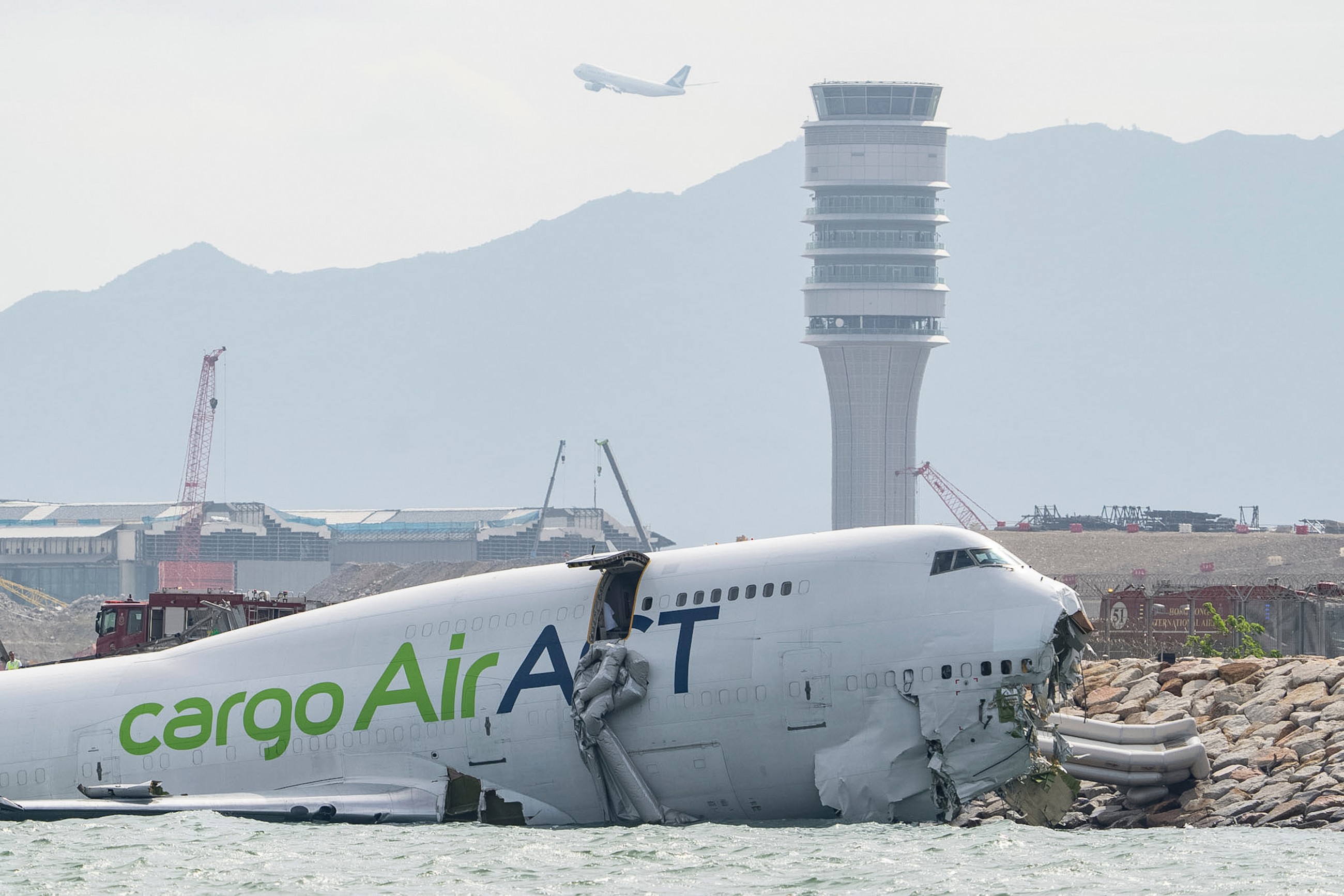 Two airport staff killed after cargo plane slides off runway in Hong Kong