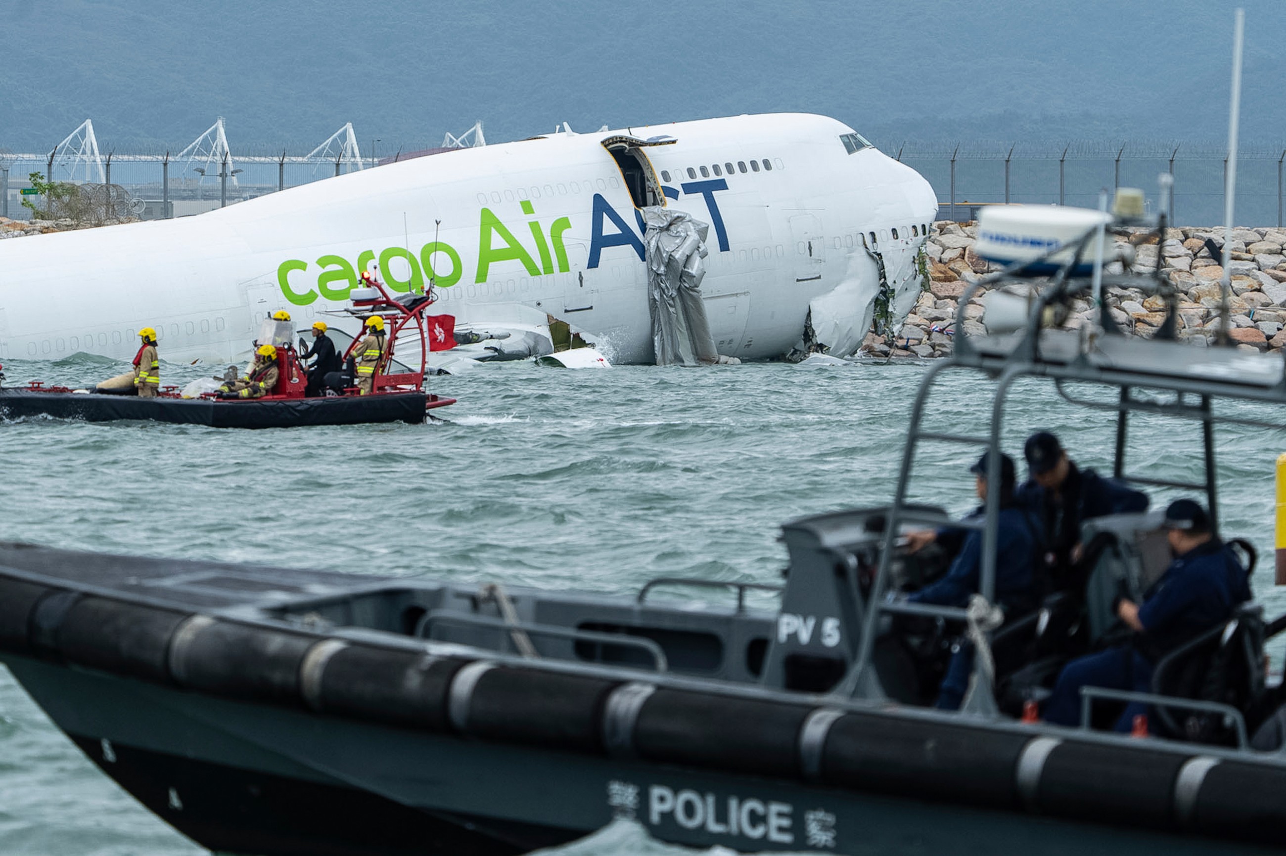 Two airport staff killed after cargo plane slides off runway in Hong Kong