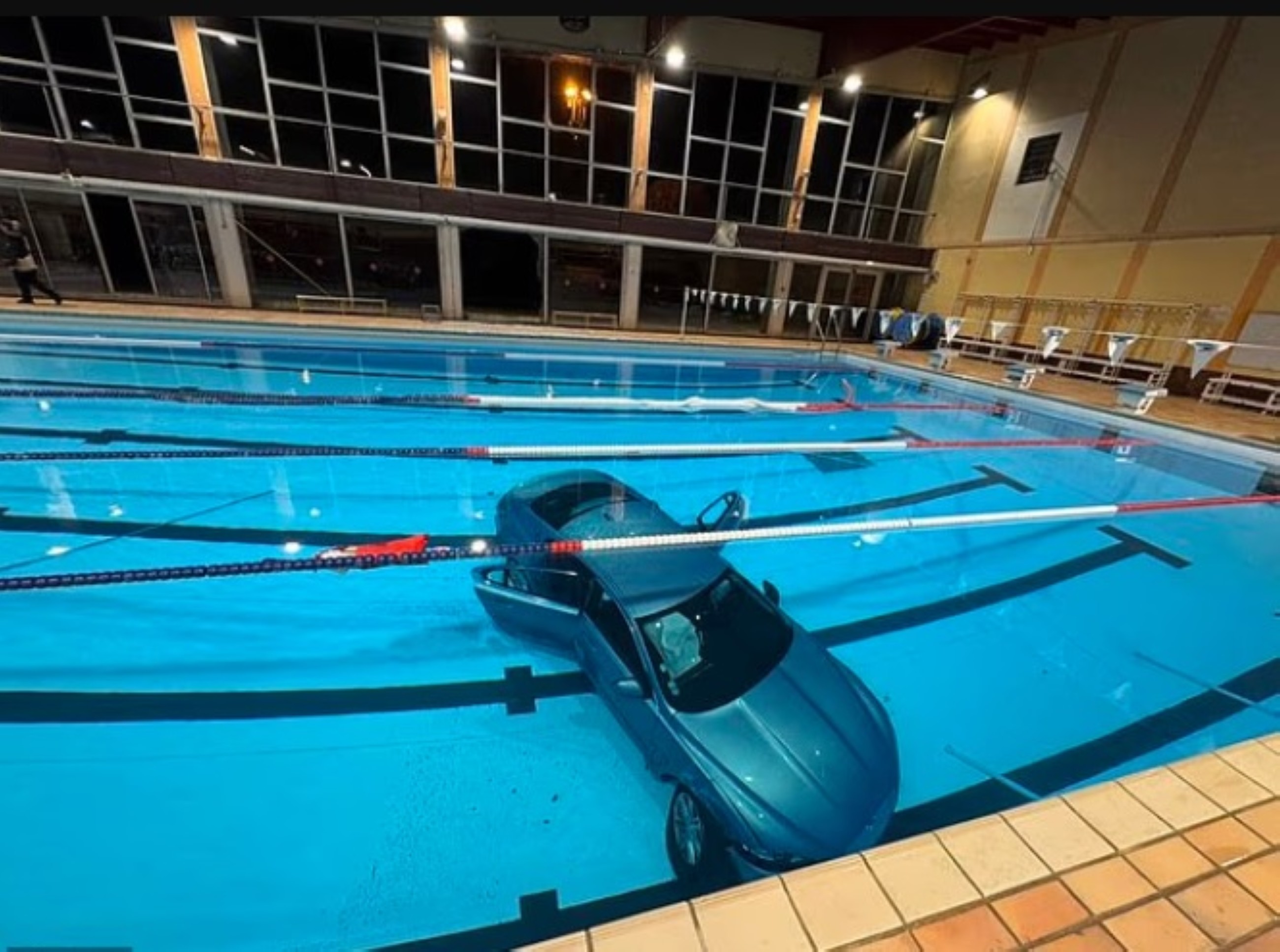 French woman driver crashes parking lots barriers, lands into swimming pool