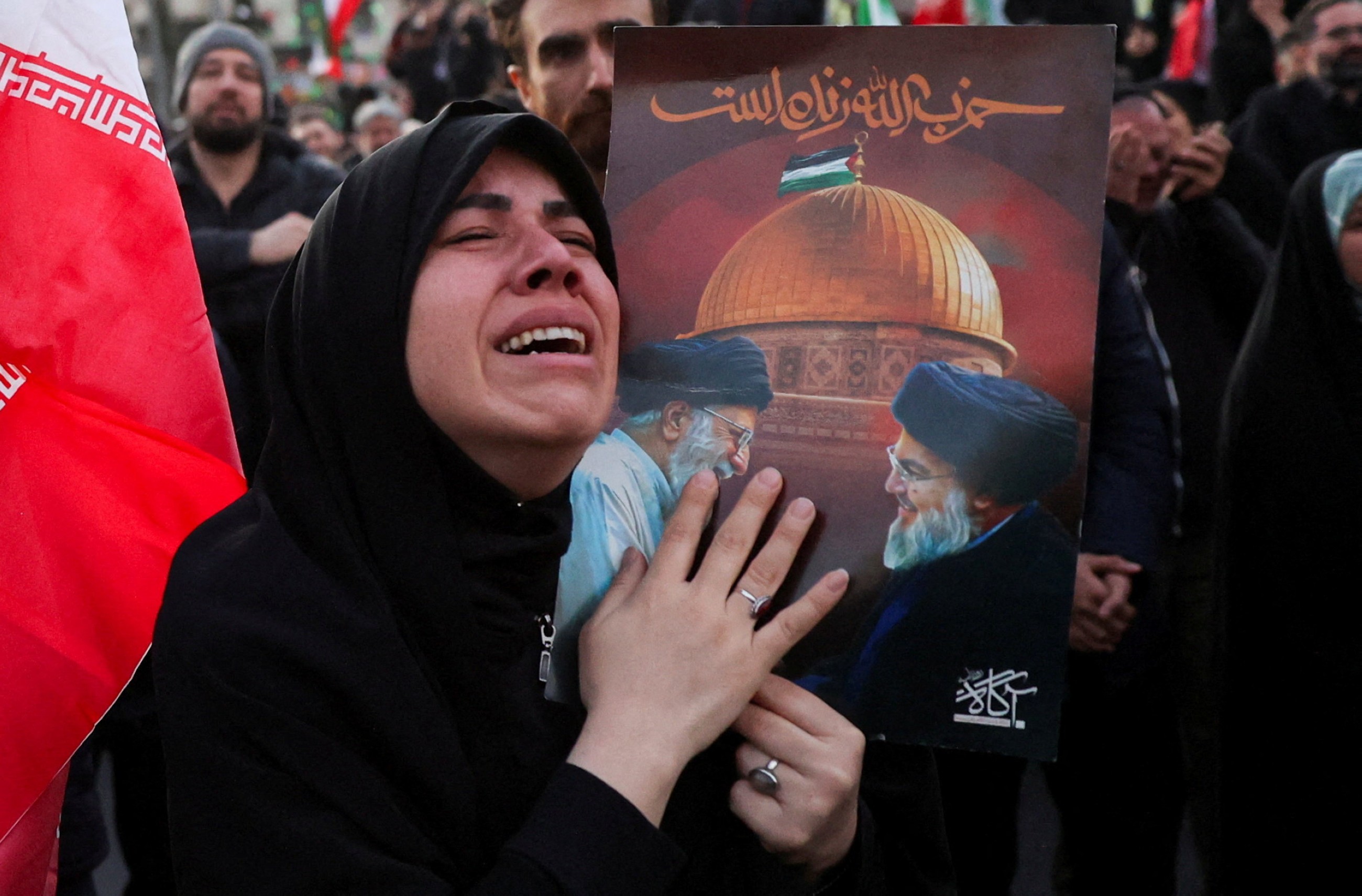 A woman reacts as people gather at the Enghelab Square