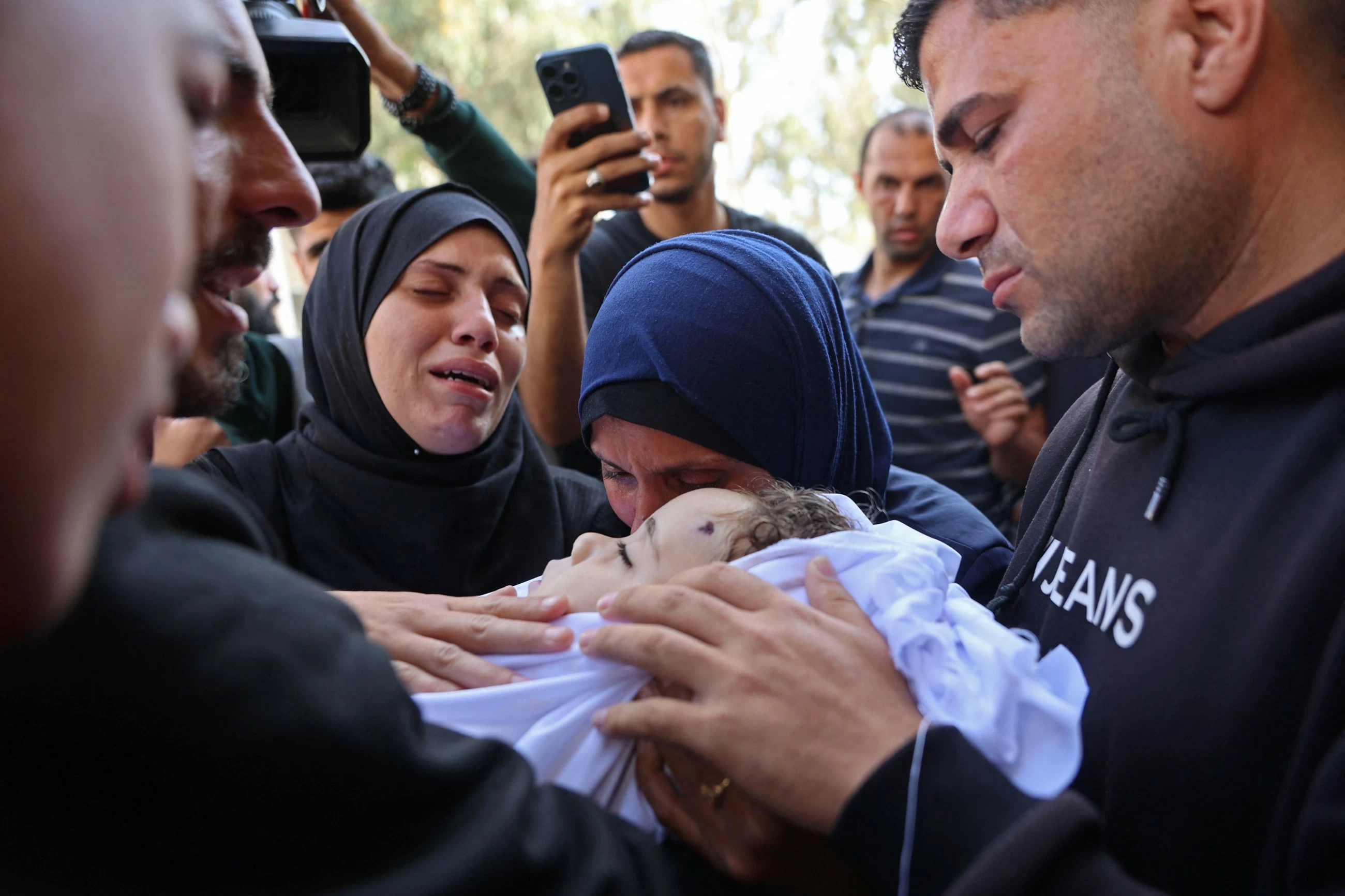 Palestinians hold funerals for pregnant woman and her children killed in Israeli strikes