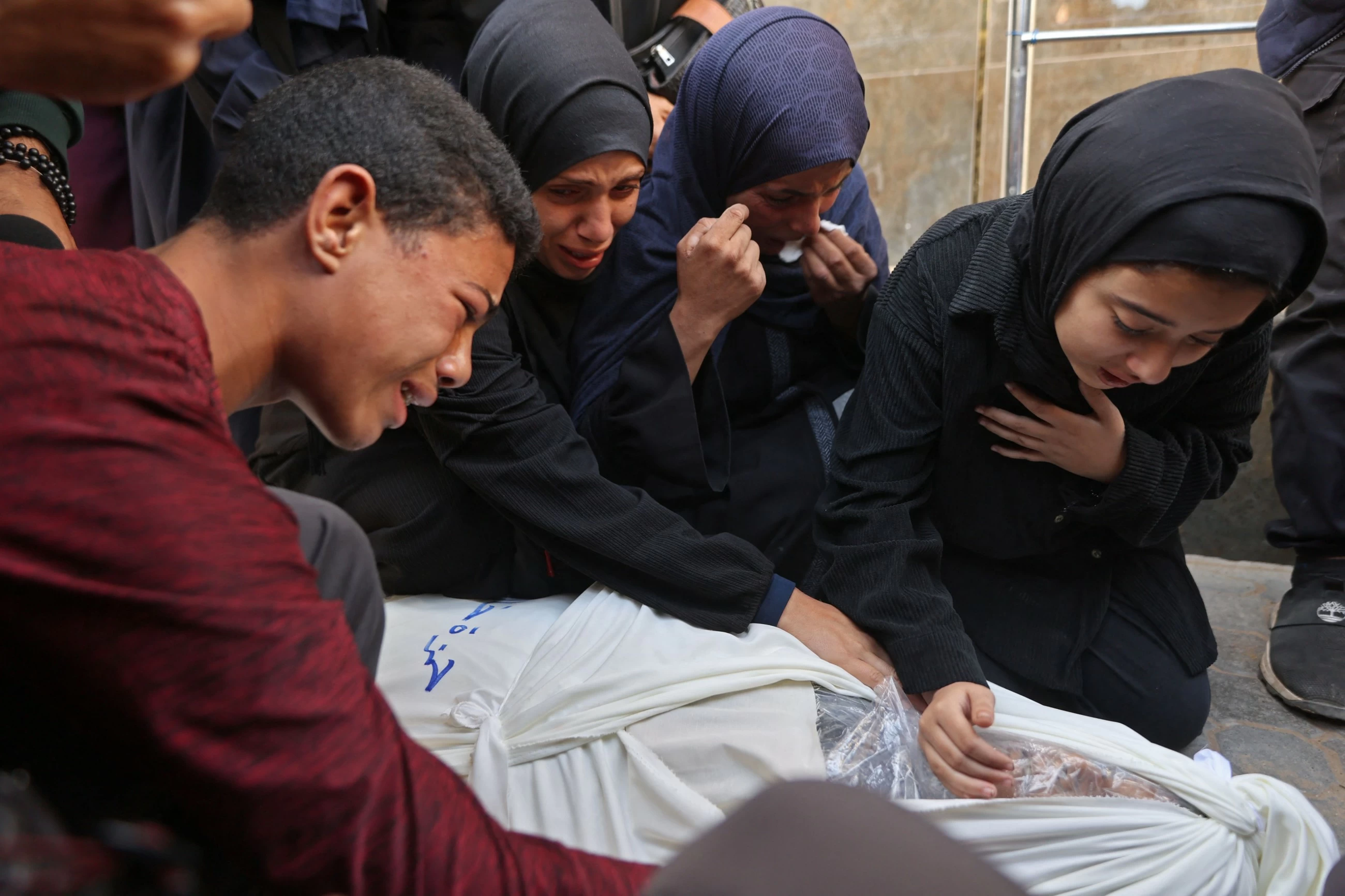 Palestinians hold funerals for pregnant woman and her chi...
