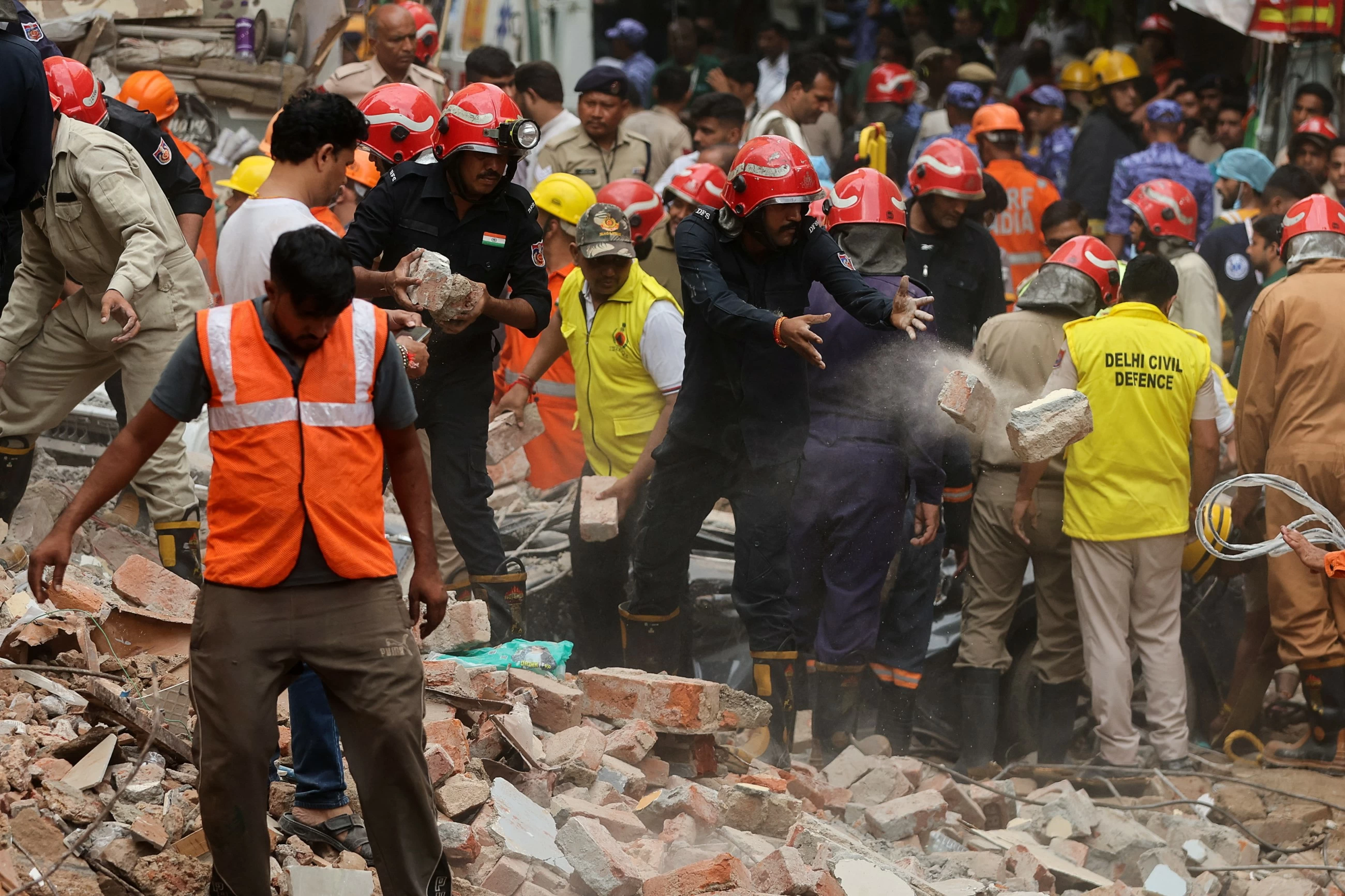 Building collapse in New Delhi kills 1 and traps dozens of others