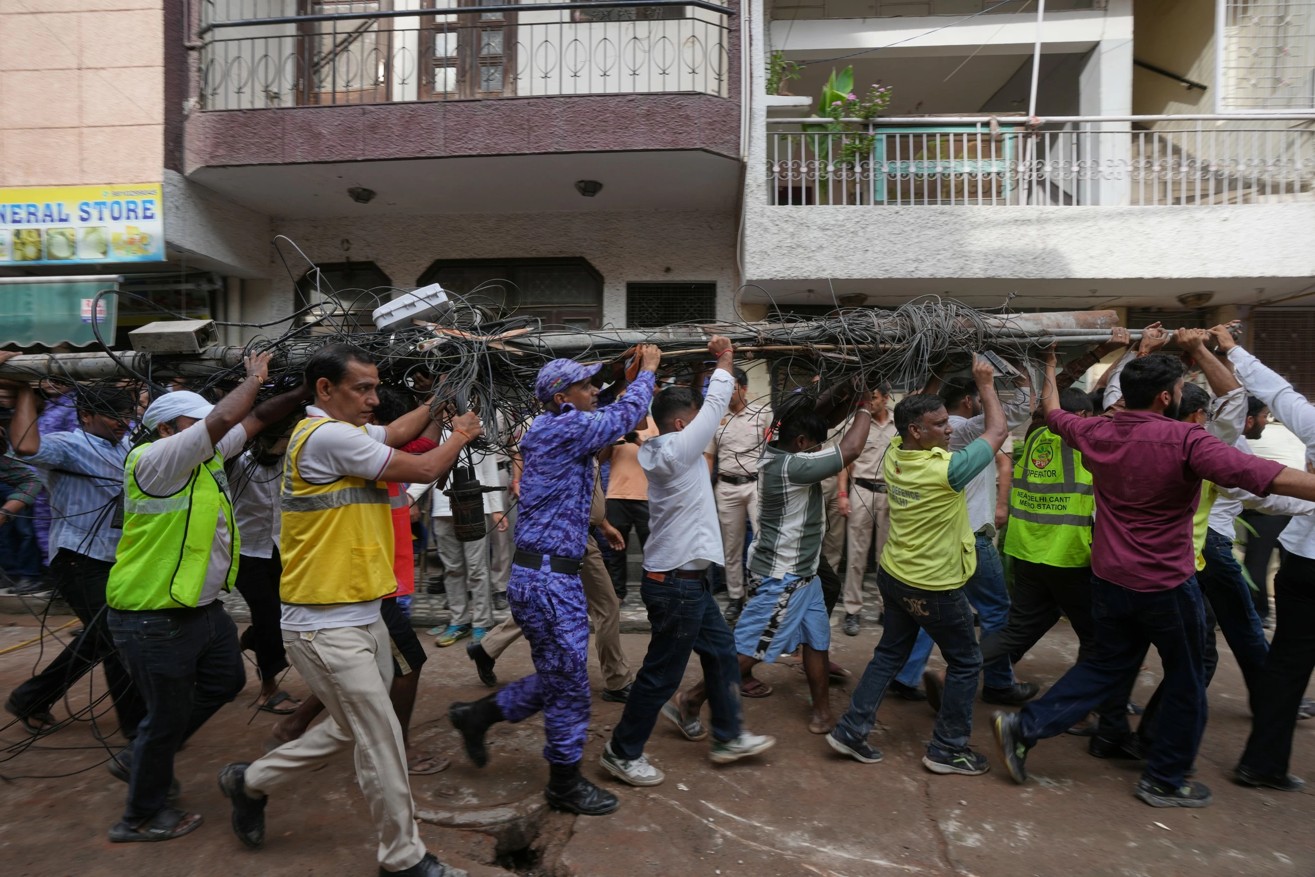 Building collapse in New Delhi kills 1 and traps dozens of others